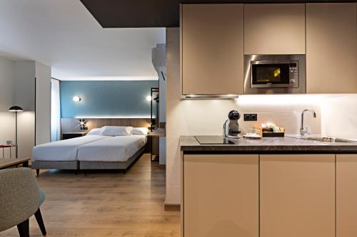 eine Küche und ein Schlafzimmer mit einem Bett in einem Zimmer in der Unterkunft Apartahotel Colón 27 in Palencia