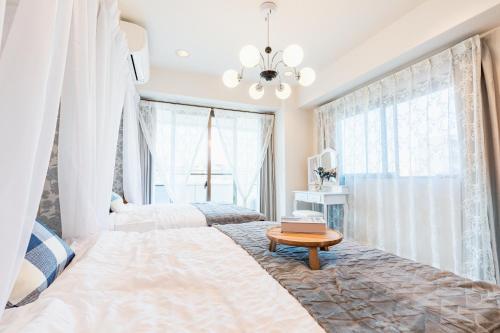 1 dormitorio con 2 camas y mesa en HARMONIA東京堀切403, en Tokio