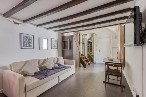 a living room with a couch and a table at L'Hypercentre / 1 min RER A - 5 min Métro - Disney in Vincennes