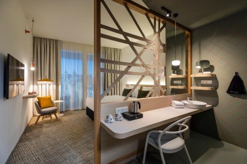 ein Hotelzimmer mit einem Waschbecken und einem Schlafzimmer in der Unterkunft ARCOTEL AQ Wien in Wien