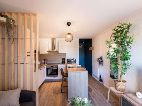 une cuisine avec des armoires blanches et un comptoir avec des plantes dans l'établissement Studio moderne pour 2 personnes avec cuisine équipée et TV à Gourette - FR-1-400-122, à Eaux-Bonnes