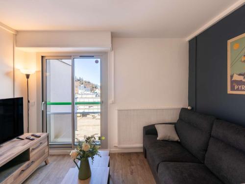 un salon avec un canapé et une grande fenêtre dans l'établissement Studio moderne pour 2 personnes avec cuisine équipée et TV à Gourette - FR-1-400-122, à Eaux-Bonnes