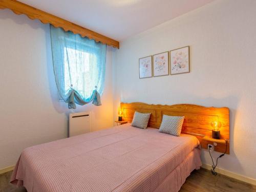 a bedroom with a bed with two lamps and a window at Charmant appart à Peyragudes 6 pers, terrasse sud, navette, parking gratuit, proche pistes et ski - FR-1-695-41 in Germ