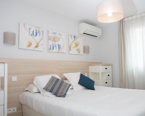 a bedroom with a large white bed with two pillows at Hotel La Ciotat - A deux pas de l'eau in La Ciotat