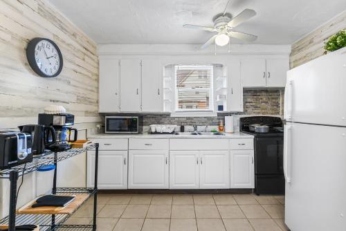 a kitchen with white cabinets and a clock on the wall at Contemporary Urban Home in Niagara Falls