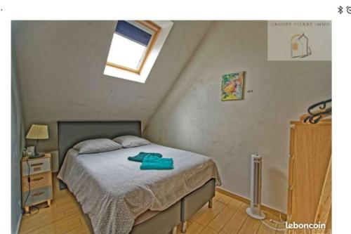 Dormitorio pequeño con cama y ventana en Orléans Appartement 2 chambres avec Parking, en Orléans