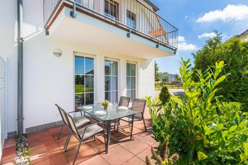 a patio with a glass table and chairs at Ferienwohnung Moin in Neddesitz