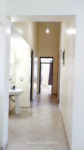 a hallway of a bathroom with a sink and a mirror at Three Bedroom at Shikara, Behind City Mall in Mombasa