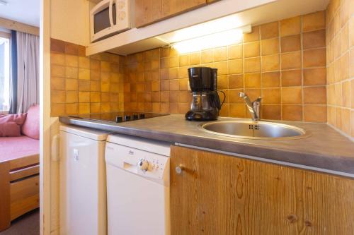 a kitchen with a sink and a coffee maker on a counter at Appartement Belle Plagne in La Plagne Tarentaise