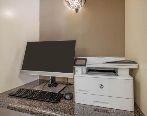 a computer desk with a monitor and a keyboard and mouse at Sonesta Simply Suites Phoenix Tempe in Tempe