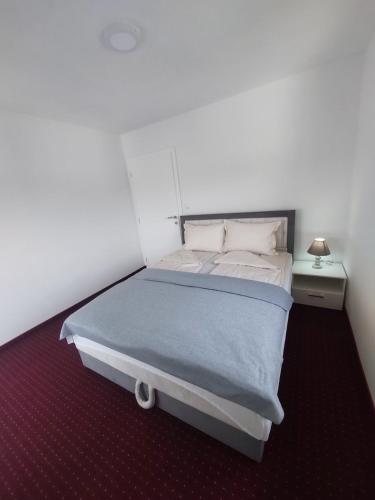 - une chambre avec un grand lit et une couverture bleue dans l'établissement Aqua Vet Apartman Velika Kladuša, à Velika Kladuša