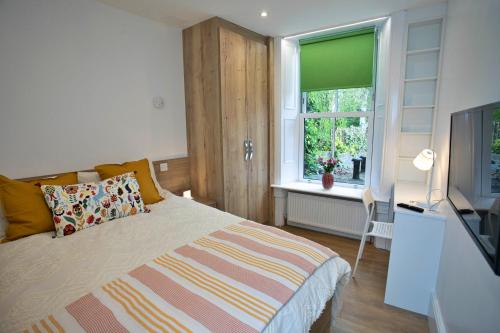 um quarto com uma cama, uma televisão e uma janela em Finest Retreats - Hill Rise em Richmond