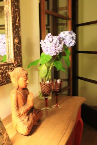 a statue sitting on a table with a vase of flowers at Donna Etrusca in Sutri