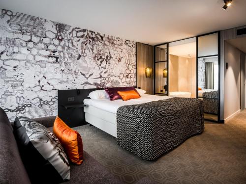 um quarto com uma cama e uma parede com graffiti em Hotel Van der Valk Maastricht em Maastricht