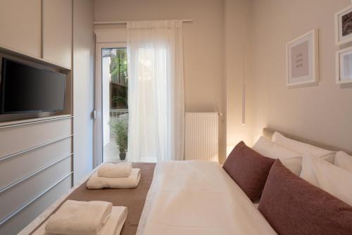 a bedroom with a bed and a tv and a window at Charming two bedrooms Apartment walk to Acropolis in Athens