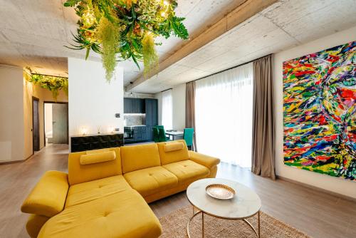 a living room with a yellow couch and a painting at Centro Accommodation in Cluj-Napoca