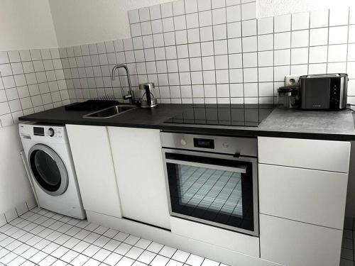 eine Küche mit einer Spüle und einer Waschmaschine in der Unterkunft Wunderschöne 3-Zimmer Wohnung für 8 Personen in Bremen