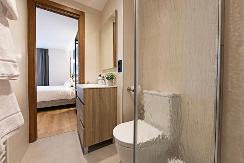 a bathroom with a shower and a toilet and a sink at Apartamentos Colón 27 in Palencia