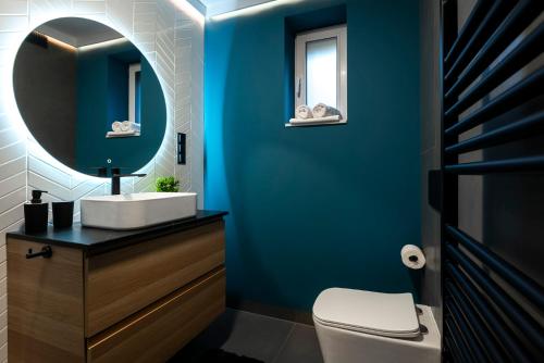 a blue bathroom with a sink and a mirror at Willa Szycha in Karpacz