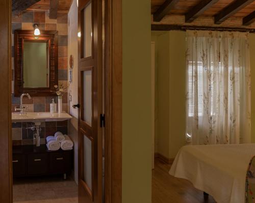 y baño con cama, lavabo y espejo. en Casa Rural Beit Shalom en Hervás
