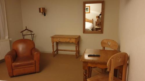 a room with a chair and a table and a mirror at Lodge Hotel Les Rousses in Les Rousses