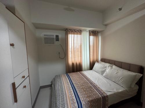 a small bedroom with a bed and a window at Sea Residences MOA Manila - Jo Alano in Manila