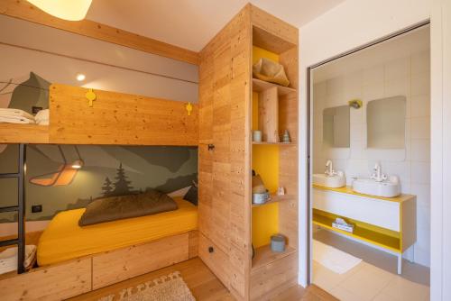 a room with a bunk bed and a bathroom at Chalet Les Galetas du Mont Blanc in Hauteluce