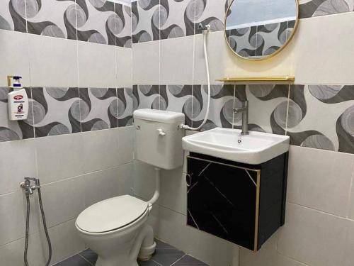 ein Badezimmer mit einem WC, einem Waschbecken und einem Spiegel in der Unterkunft MS HOMESTAY in Arau