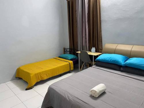 ein Zimmer mit 2 Betten und einem Tisch mit einer Kichererbse in der Unterkunft MS HOMESTAY in Arau