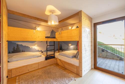 two beds in a room with a balcony at Chalet Les Galetas du Mont Blanc in Hauteluce