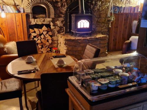 a living room with a table and a fireplace at Lodge Hotel Les Rousses in Les Rousses