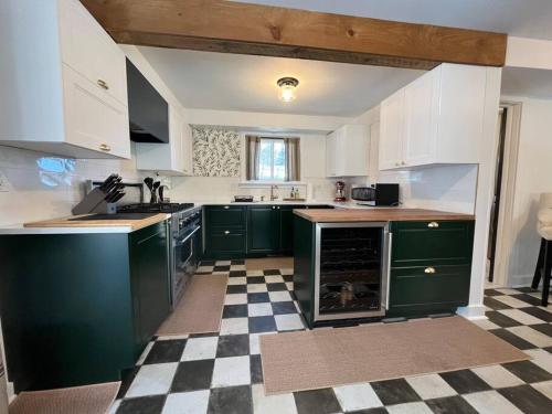 a kitchen with green cabinets and a checkered floor at Litchfield Modern Farmhouse in Litchfield