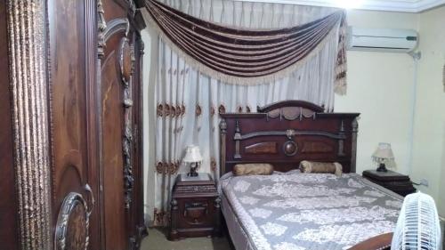 a bedroom with a wooden bed with a canopy at Jad apartment in Irbid