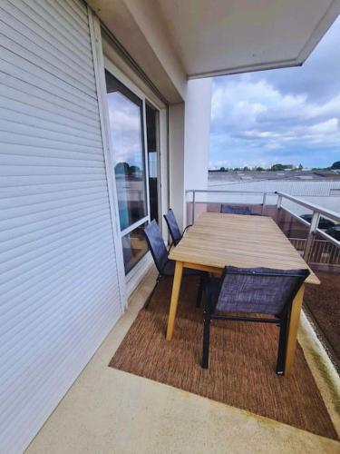 - une table et un banc en bois sur le balcon d'une maison dans l'établissement T4 proche de tout ! Séjour parfait garanti, à Saint-Herblain
