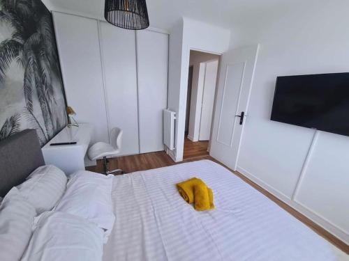a bedroom with a bed with a yellow towel on it at T4 proche de tout ! Séjour parfait garanti in Saint-Herblain