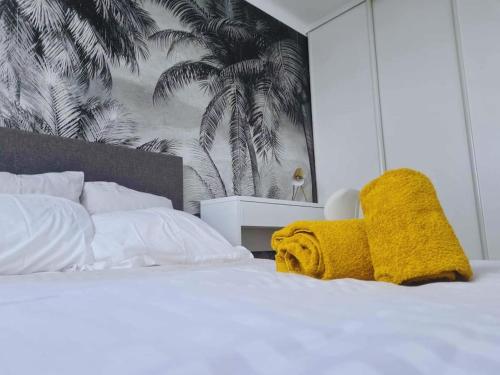 a bedroom with a white bed with a yellow blanket at T4 proche de tout ! Séjour parfait garanti in Saint-Herblain