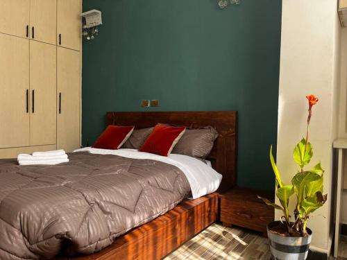 - une chambre avec un grand lit et des oreillers rouges dans l'établissement ጉዲት:ቤት /Haus of GOODiT, à Addis-Abeba