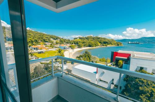 a balcony with a view of a beach and water at Hotel Villareal São Francisco do Sul in São Francisco do Sul