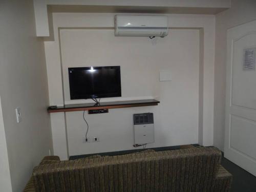 uma sala de estar com um sofá e uma televisão na parede em ALBERDI centro MENDOZA em Mendoza
