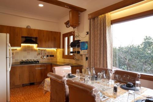 Galaxy Stay Casa في Bhowāli: مطبخ مع طاولة مع كؤوس للنبيذ عليه