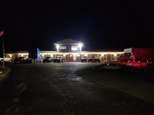 a gas station at night with cars parked in a parking lot at Norvic Motel in Coniston