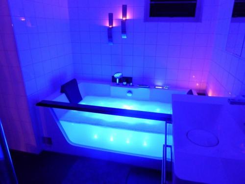 a bathroom with a tub with purple lights in it at Villa Beach & Golf in Julianadorp