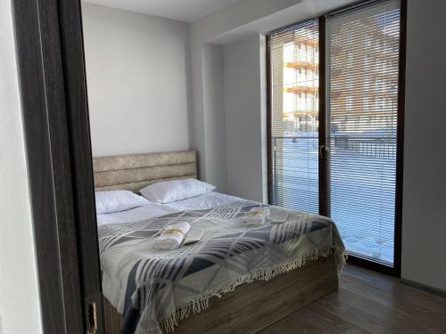 een slaapkamer met een bed en een groot raam bij New Gudauri Loft 2 in Goedaoeri