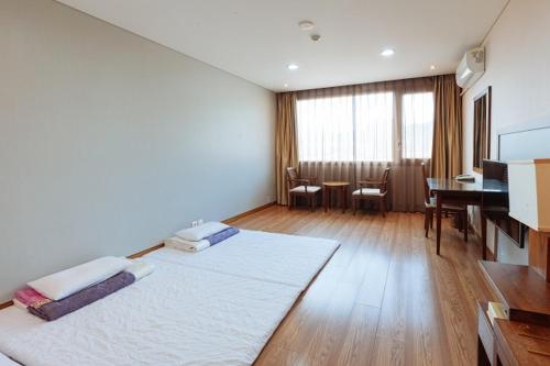 a room with a bed and a table and a desk at Damyang Spa and Tourist Hotel in Damyang
