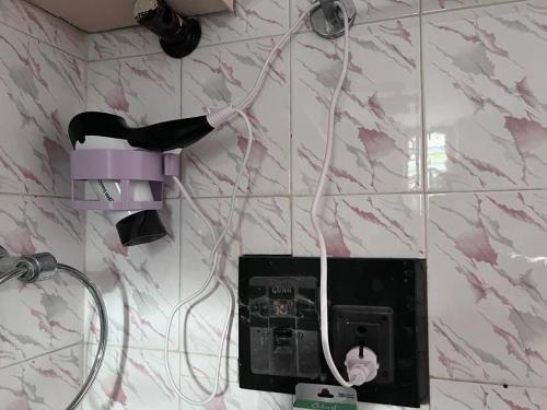 a pink light on a wall with a hair dryer at 2BHK with parking & ample space in Bangalore