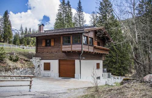a wooden house with a garage in the woods at Holiday home in Campo Carlo Magno 24162 in Madonna di Campiglio