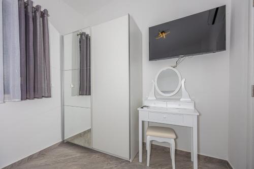 a white bathroom with a vanity and a mirror at VILLA NINA MALINSKA 150m FROM THE BEACH, SWIMMING POOL in Vantačići