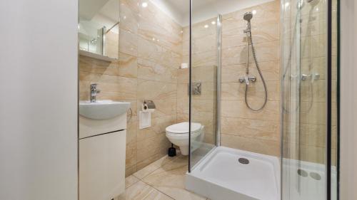 uma casa de banho com um chuveiro, um WC e um lavatório. em Apartamenty Sun & Snow Grunwaldzka em Sopot