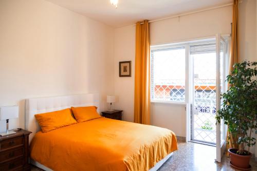 een slaapkamer met een oranje bed en een raam bij AURELIA LORIS HOUSE in Rome