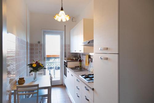 een keuken met witte kasten en een witte koelkast bij AURELIA LORIS HOUSE in Rome
